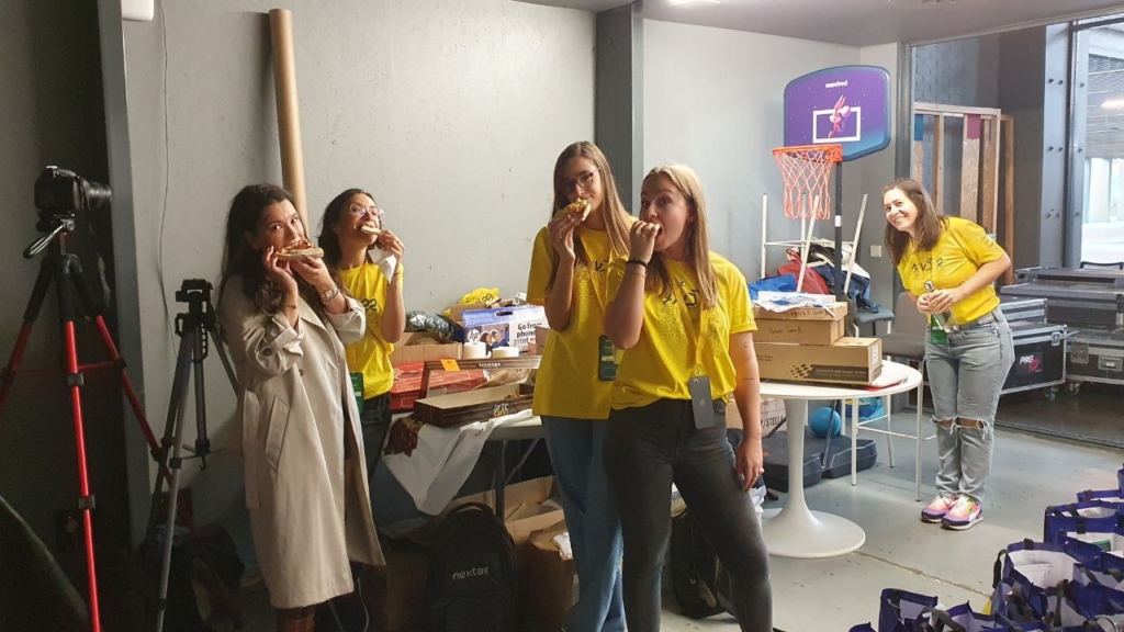 Foto de un grupo de voluntarios haciendo una pausa y comiendo pizza.